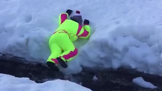 Yellow winter suit tries to jump creek and falls in