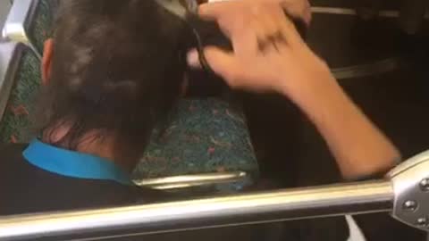 Man cutting hair with scissors on train