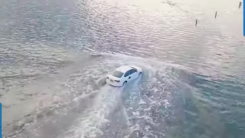 TAXI DRIVER STEERS THROUGH THE MID SEA