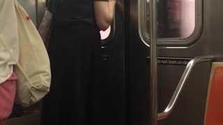Guy green shirt pony tail staring at subway door