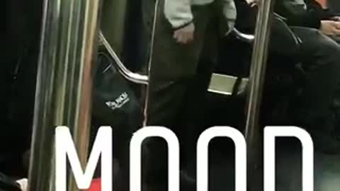 Guy in grey jacket dances and sways on subway