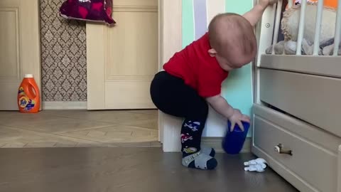 Determined kid gives all his best to pick up toy