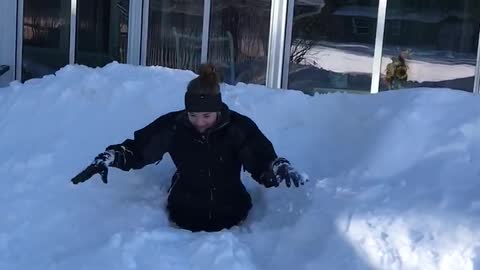 Girl black sweats jumps off roof buried in snow to waist