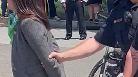 Is AOC pretending to be handcuffed as she’s escorted from a protest outside the Supreme Court?