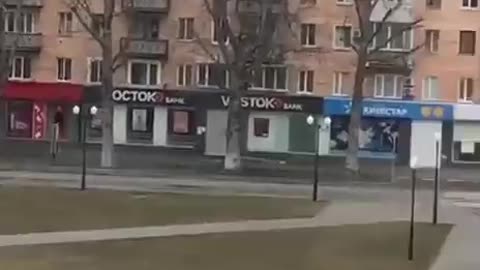 Ukrainian raises the Ukrainian flag in front of the Russian army in defiance of them