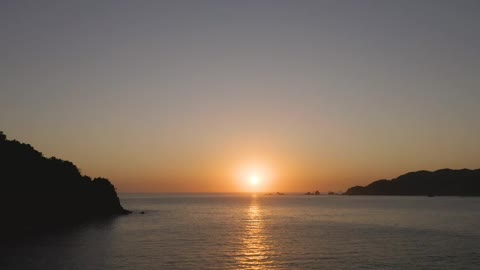 Sun setting on the horizon line at sea
