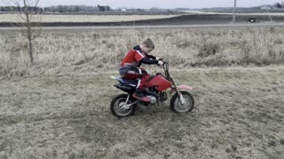 Kid trying to kickstart start dirt bike