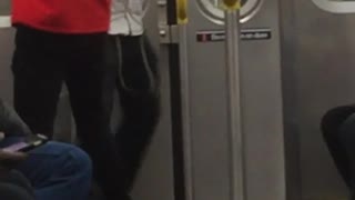 Guy in white shirt and red sweater fighting with swords on subway train