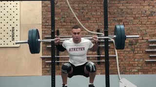 Man Is Doing Barbell Squats On A Seesaw