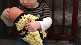 Toddler prepares to become big brother by caring for doll