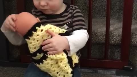 Toddler prepares to become big brother by caring for doll