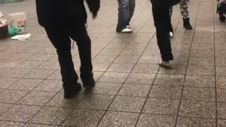 Four men gather to dance in circle at subway station