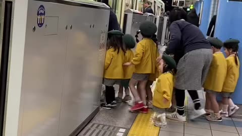 Cute Japanese kids waiting for the train.