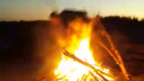 Adventurous Guy Jumps Over Fire With A Large Branch