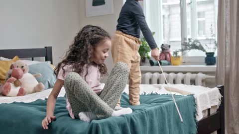 Children playing with their cat in the bedroom