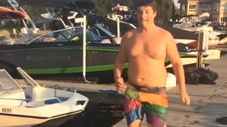 Chunky guy slips on pier while trying to run to water for a dive