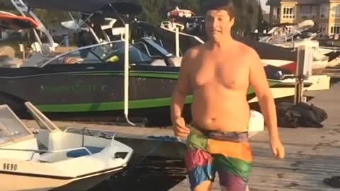 Chunky guy slips on pier while trying to run to water for a dive