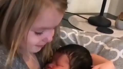 five -year-old girl excitedly meets her newborn baby brother sweetly cuddles