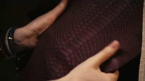 hands touching the leather of a python snake