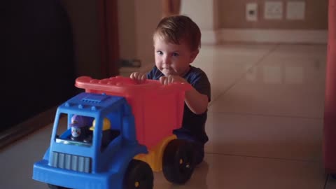A small child plays with a big truck
