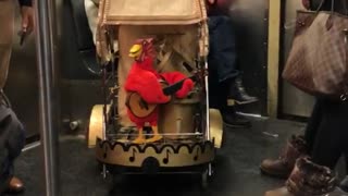 Red toy bird on stroller in subway