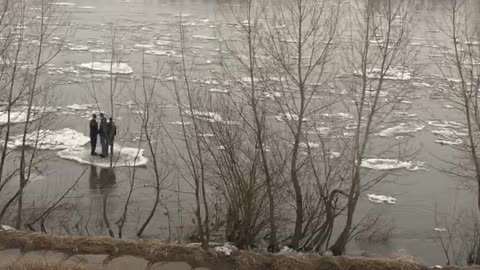 People Floating on Ice in a River