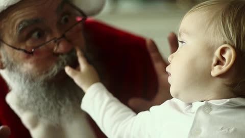 Santa Claus Making Faces With A Baby