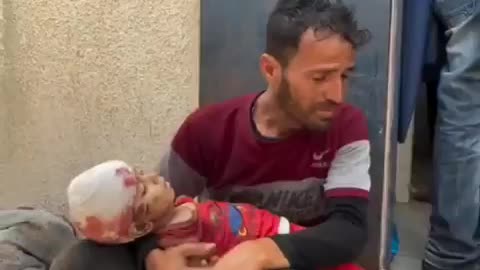 Traumatized father carries his child who was murdered in Israel's latest massacre