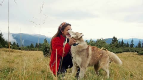 Young female playing and wrunning with siberian husky dog in mountains on path