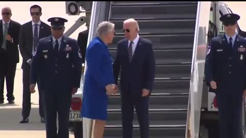 Man in Blue Dress Hugs Biden Stepping off of Air Force One