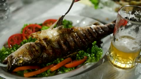 pouring a sauce on cooked fish