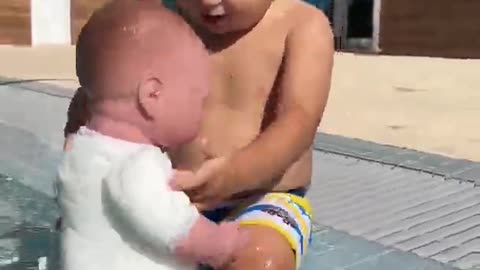 Baby David is playing in the pool with doll.