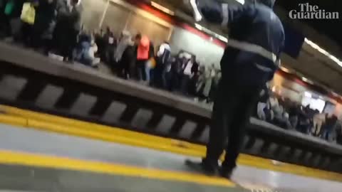 People run for cover as Iranian police open fire during protest at Tehran metro station