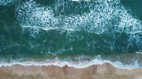 Aerial view of sand beach. Top view sea waves. Drone footage