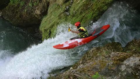 LO MO Whitewater kayaker dropping a waterfall and diving into the plunge pool stock video