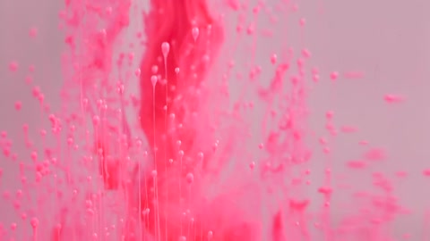 Dynamic movement of pink ink clouds in water