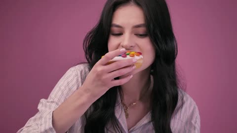 Girl eating a glazed donut with a milkshake