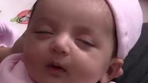 The baby is smiling and sleeping. What is the baby dreaming about?