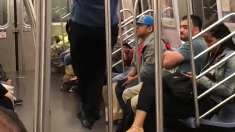 Guy blue shirt black pants doing pull ups in subway