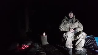 Adjusting the light source while filming a nighy vlog by a campfire