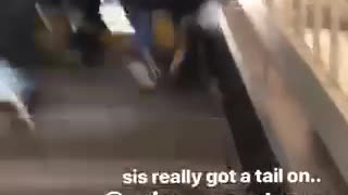 Girl runs up subway stairs with tail on