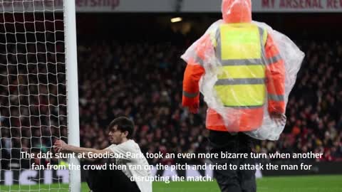 PAIN IN NECK Protester ties his NECK to goalpost at Everton before being cut free.