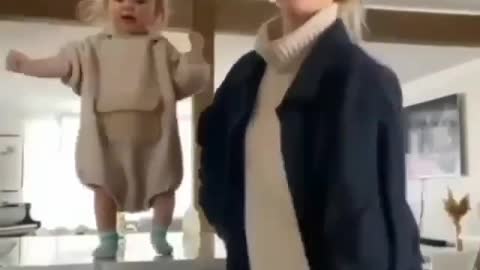 Little girl trying to dance with momma