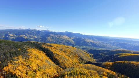 flying-forward-through-fall-foliage-and-over-cliff-in-colorado-rocky-mountains_rq-smhryg__D4k