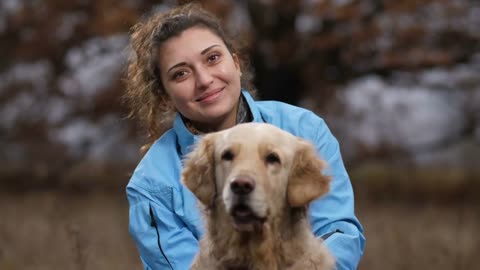 Portrait of joyful young woman with curly hair and labrador retriever posing