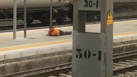 Chill out bro man in orange laying on train platform