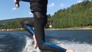 Guy in blue wetsuit jumps off boat and into water
