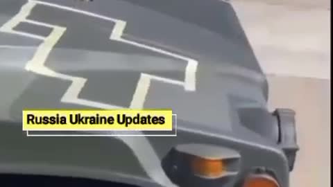 Ukrainian servicemen apply camouflage to vehicles transferred by the American army