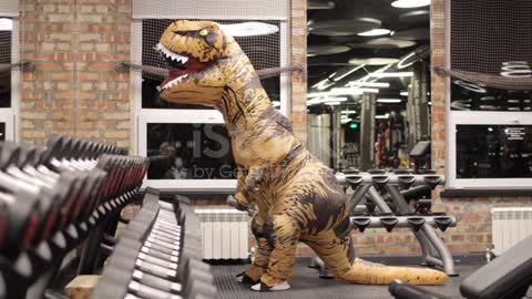 A dinosaur trying to exercise in the gym funny
