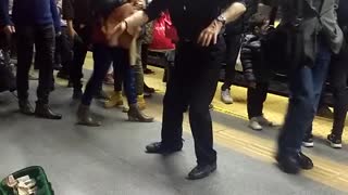 Old man in black dancing in subway station